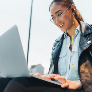 Businesswoman, sitting outdoors, using laptop, on video call, low angle view