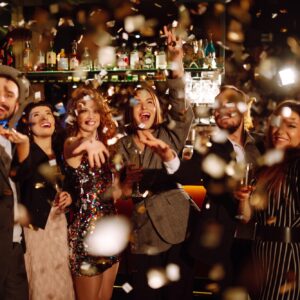 Happy friends throwing confetti and jumping while enjoying party Confetti is fun. Party, celebration